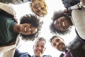 group of professionals standing in a circle and smiling