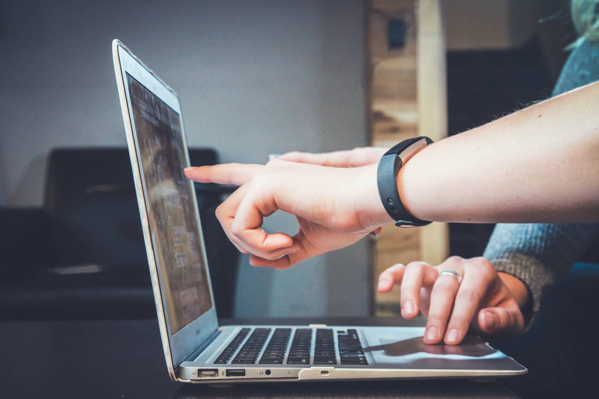 person pointing to laptop screen